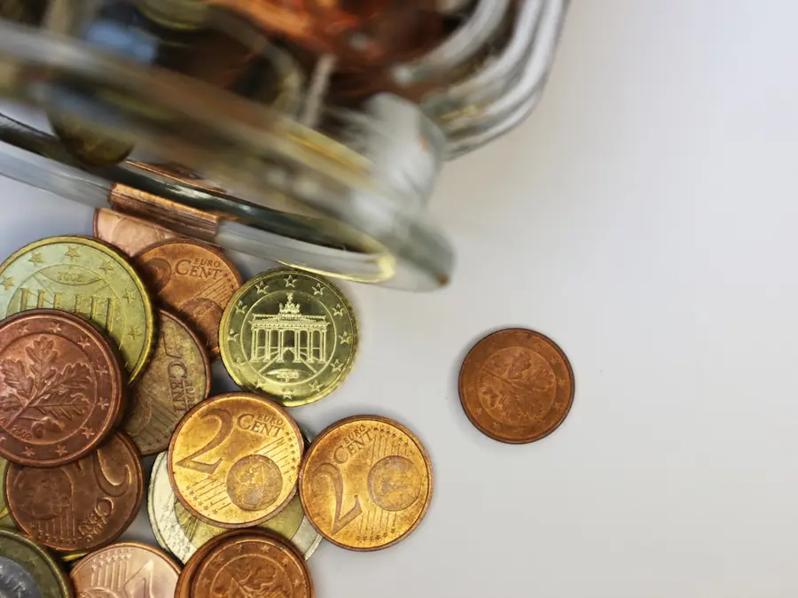 Euromünzen liegen vor einem umgekippten Sparglas